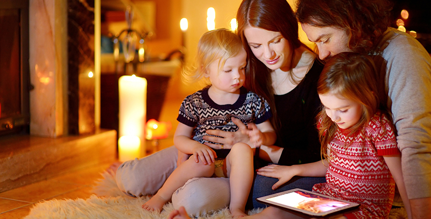 Family using tablet by candle light - Power Outage Notifications
